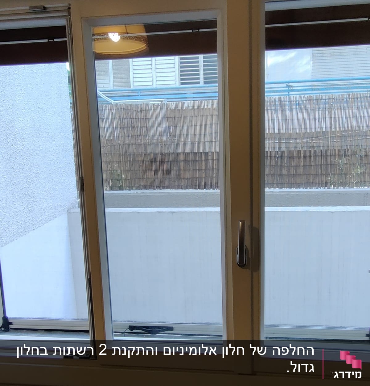 חלון אלומיניום עם מסגרת לבנה וידיות פתיחה